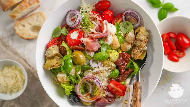 Italienischer Salat mit Mozzarella, Antipasti und Parmaschinken