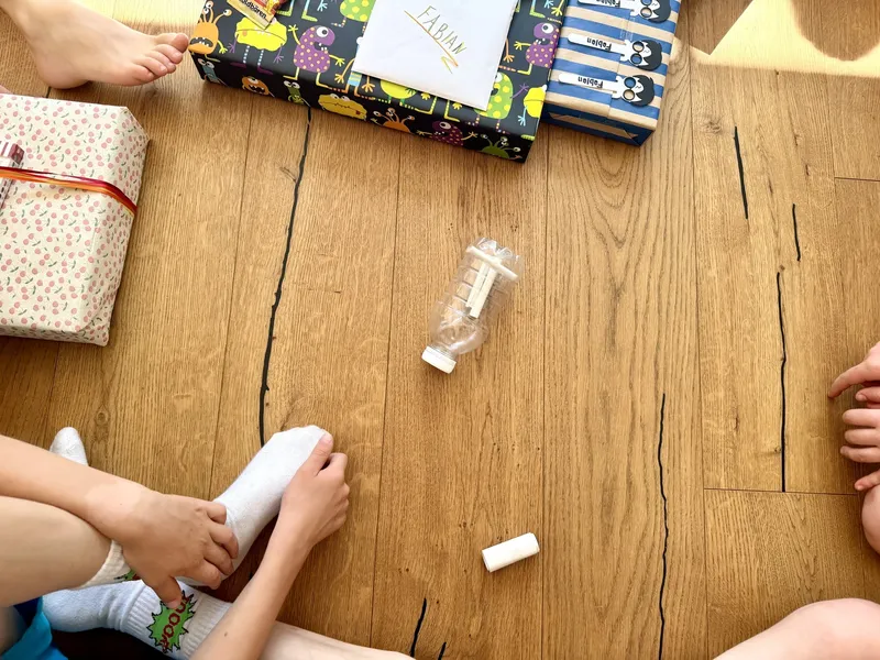 Geschenke auspacken am Kindergeburtstag: Flaschendrehen mit coolen Aufgaben für ältere Kinder