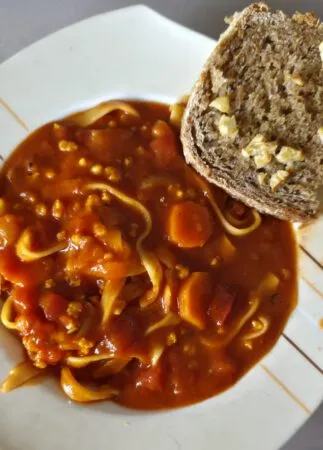 Vegane Nudel-Tomaten-Suppe mit gerettetem Knoblauchbrot